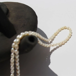 Elegant freshwater rice pearl necklace with French vintage style on grey vessel