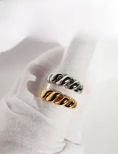 Detail view of gold and silver twisted spiral open rings with high-polish mirror finish