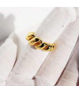 Macro detail of the golden vintage twisted rope ring with a high-polished metallic finish