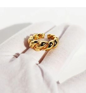 Macro shot of gold twist rope ring detail showing adjustable open band and metallic gloss