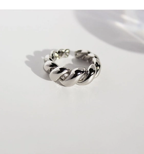 Macro shot of silver twisted rope textured open ring with polished metal finish
