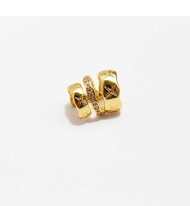 Macro shot of gold-plated ear cuff with pavé zircon stones and quilted texture pattern
