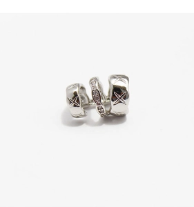 Macro detail of silver triple-layer ear cuff with star patterns and zircon inlays