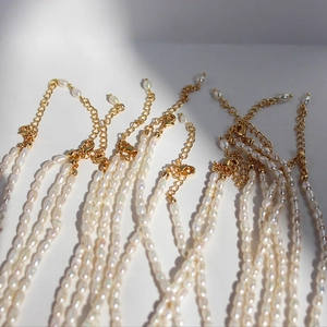 Elegante collar de perlas naturales de agua dulce con cierre dorado sobre fondo blanco