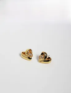 Gros plan détaillé des boucles d'oreilles cœur dorées avec design multicouche et zircons