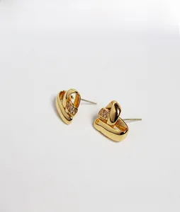 Détails des élégantes boucles d'oreilles nœuds dorés avec incrustation de zircon