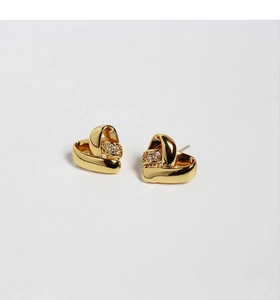 Détail de boucles d'oreilles cœur dorées avec oxydes de zirconium et tige en argent S925