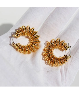 Detailed view of gold spiral hoop earrings featuring 3D twisted wire and stud closures