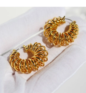Macro view of gold-plated brass spiral hoop earrings with layered coil design