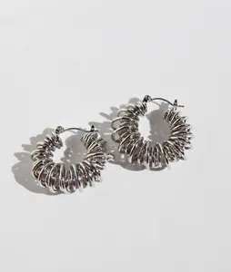 Macro shot of silver spiral hoop earrings with unique spring texture and secure clasp