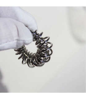 Detail shot of a professional silver ring sizer tool held by gloved hand on light background