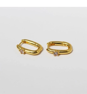 Detailed macro view of gold-plated U-shaped earrings with sparkling cubic zirconia inlay