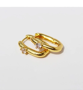 Detail of gold plated U-shaped hoop earrings featuring a sparkling center zircon stone