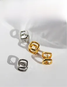 Detailed view of geometric hollow square earrings in gold and silver plating with shadows
