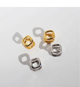 Detailed view of geometric square gold and silver brass earrings with high polish finish