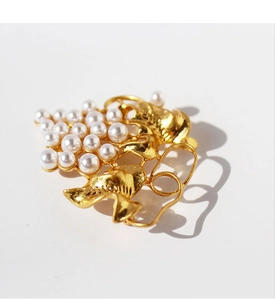 Detailed macro of gold plated brass grape brooch with cluster of elegant white pearls