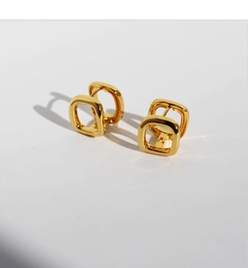 Macro shot of geometric square gold plated brass hoop earrings with high polish finish