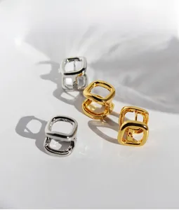 Detailed view of minimalist geometric square hoop earrings in gold and silver finish