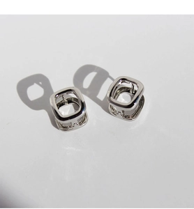 Polished silver geometric square ear buckles with minimalist hollow design in macro view