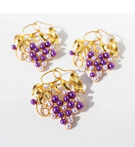 Detailed cluster of gold grape leaf brooches featuring elegant purple pearl beads