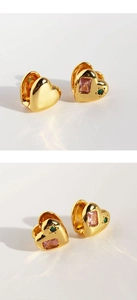 Detail view of heart-shaped gold earring with pink rectangular stone and green star zircon