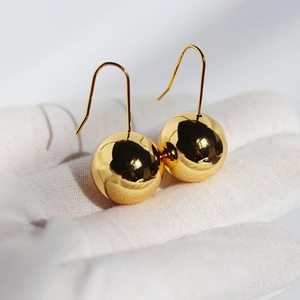 Polished gold spherical drop earrings for women with a minimalist modern design