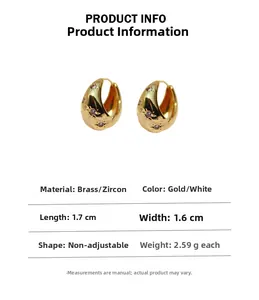 Detail of gold brass hoop earrings with engraved stars and purple zircon stones