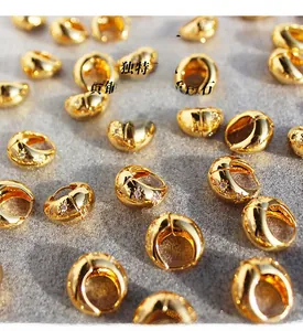 Macro shot of gold-plated brass hoop earrings featuring inlaid high-quality zircon stars