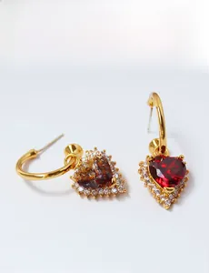 Close-up of vintage gold heart earrings with large red ruby and white zircon halo