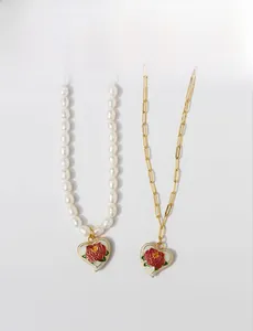 Detailed view of vintage enamel rose heart pendants on pearl and gold paperclip chains