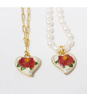 Detail of vintage heart enamel rose pendants with gold link and pearl chain necklace
