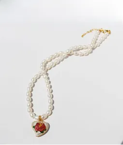 Detail of heart pendant with red rose enamel and natural freshwater pearls on gold necklace