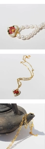 Detail of vintage heart enamel rose pendant with freshwater pearl necklace and gold chain