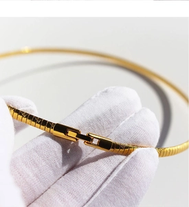 Macro view of gold plated square snake bone choker with secure snap closure clasp