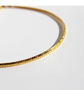 Macro shot of 18k gold plated square snake chain showing delicate textures and glossy finish