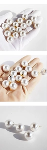 Macro detail of large round white pearls with gold base and sterling silver posts