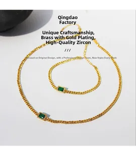 Detailed set of gold plated brass chain necklace and bracelet with emerald green zircon