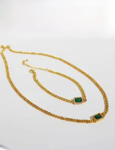 Detailed view of vintage gold chain necklace with emerald green rectangular gemstone
