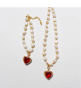 Dettaglio di set di perle d'acqua dolce con pendente a cuore rosso e zirconi lucidi