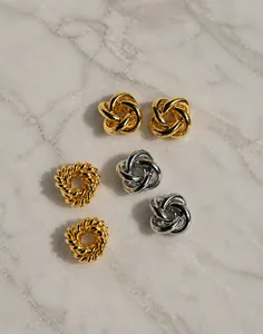 Détail de boucles d'oreilles torsadées en or et argent avec finition polie brillante