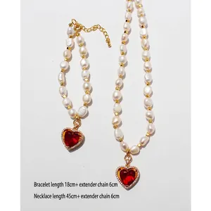 Set gioielli vintage con perle d'acqua dolce e ciondolo a cuore rosso su sfondo bianco