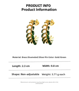 Detail showing vintage leaf-shaped earrings with green enamel coating and brass finish