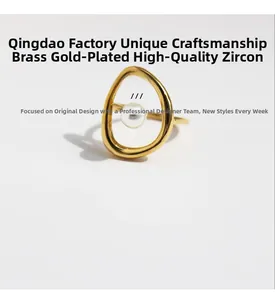 Détail d'une bague en laiton doré aux lignes organiques avec perle blanche et zircon