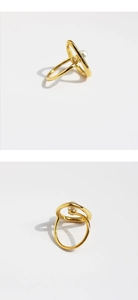 Gros plan de la bague abstraite dorée avec perle et lignes géométriques métalliques creuses