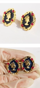 Detail der Vintage-Ohrringe mit Elizabeth-Relief und roten Kristallelementen