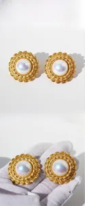 Dettaglio di orecchini vintage a girasole con pietra iridescente e finitura dorata