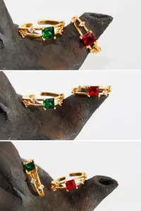 Dettaglio di anello dorato regolabile con zircone verde smeraldo quadrato e fascia aperta