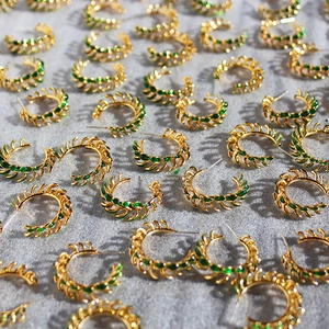 Vintage gold hoop earrings with green enamel leaves and textured metal finish