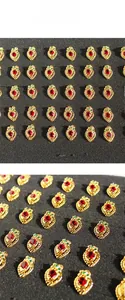 Detailed close-up of retro heart-shaped brass earrings with red zircon and gold-plated finish