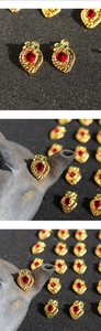 Macro detail of vintage berry earrings with red teardrop stones and gold rope edges